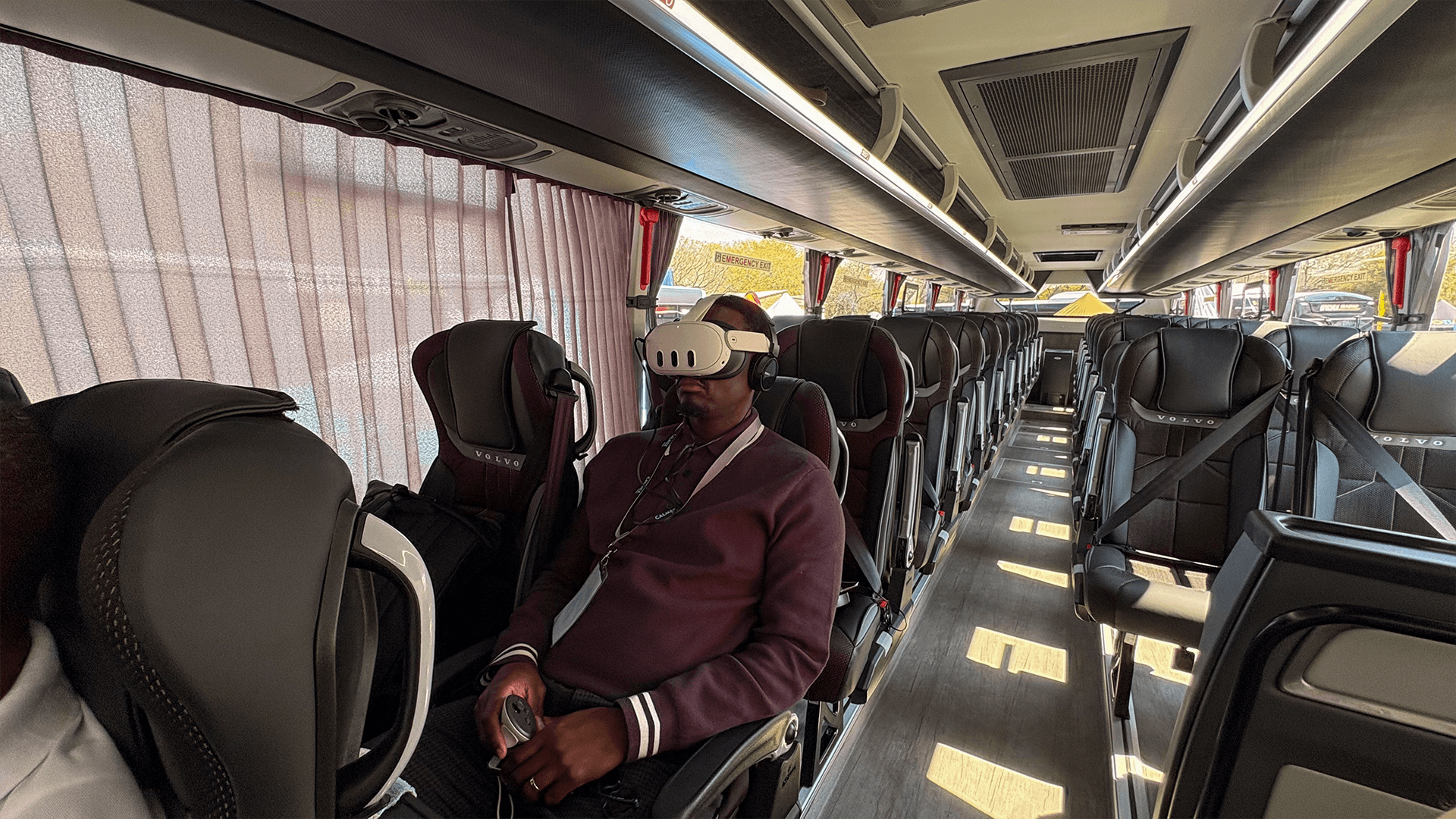 Guests wearing virtual reality headsets while seated inside a coach