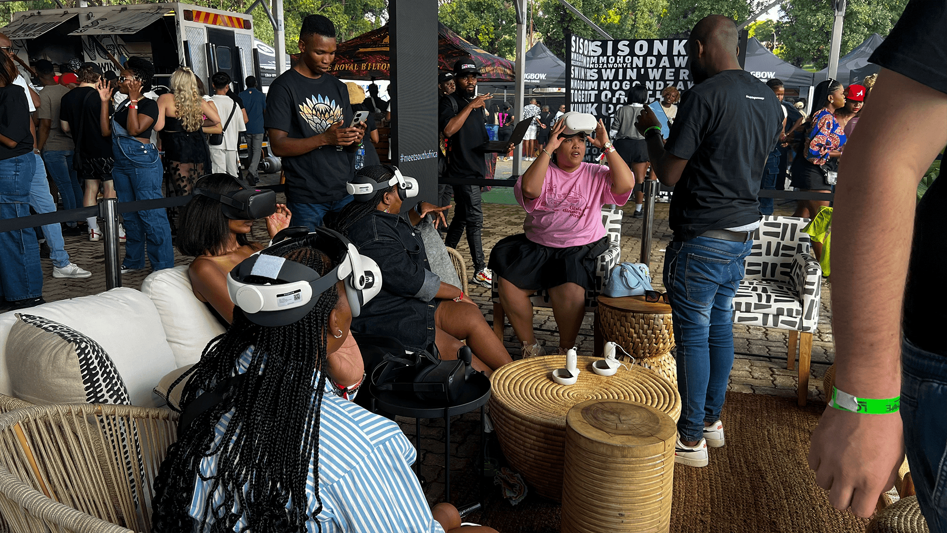 Guests trying VR headsets in a busy exhibition seating area
