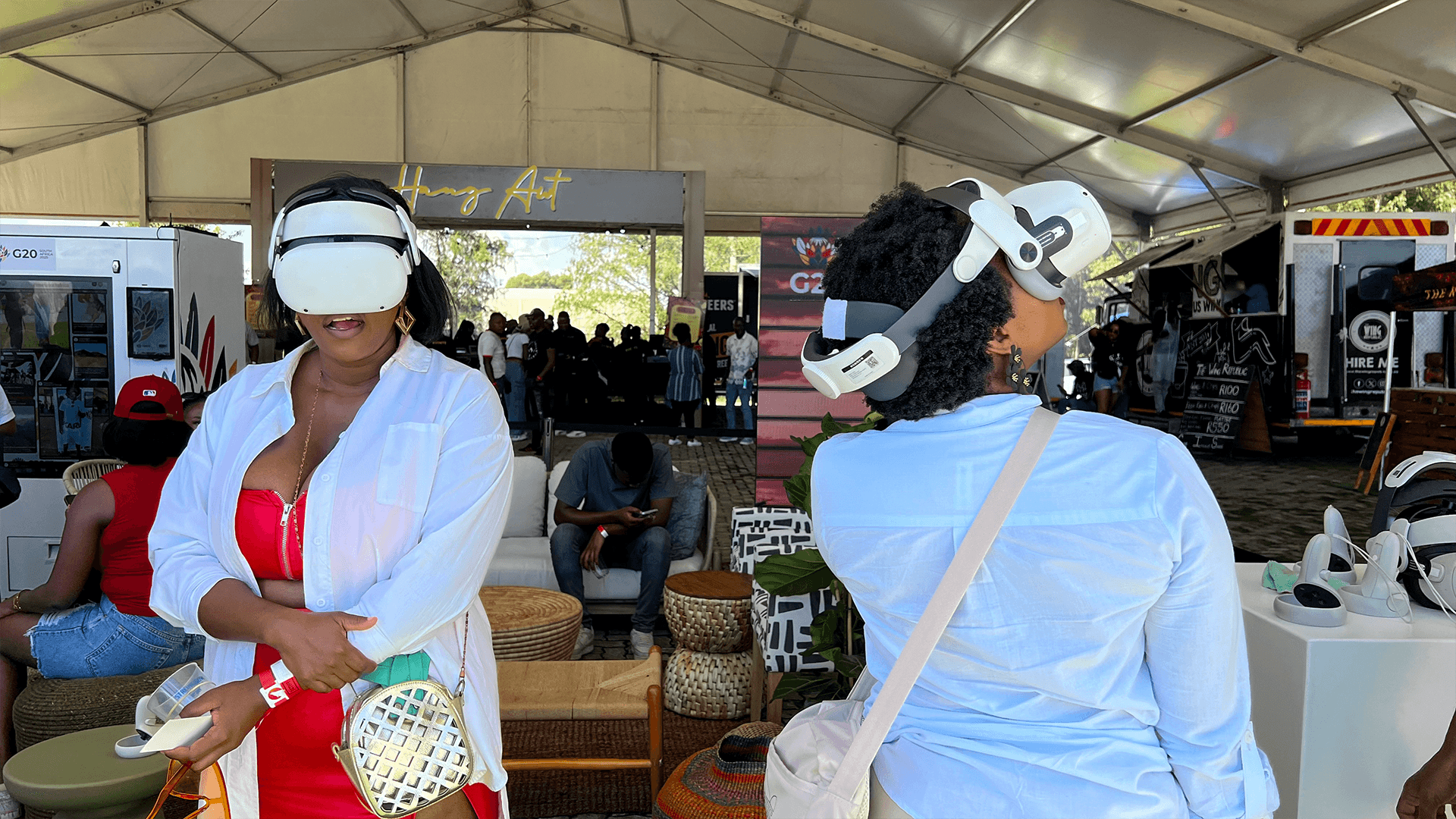 Two guests wearing VR headsets at a tented event