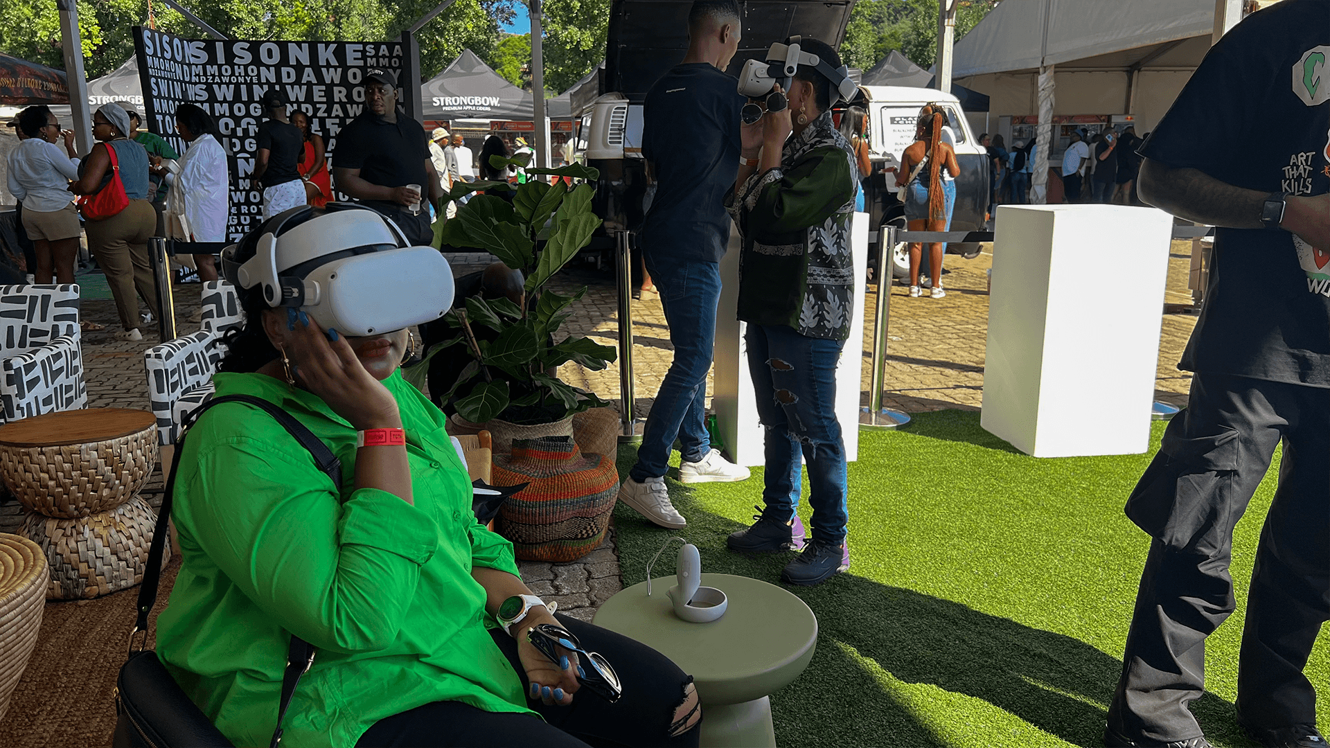 A seated guest wearing a VR headset beside an event display