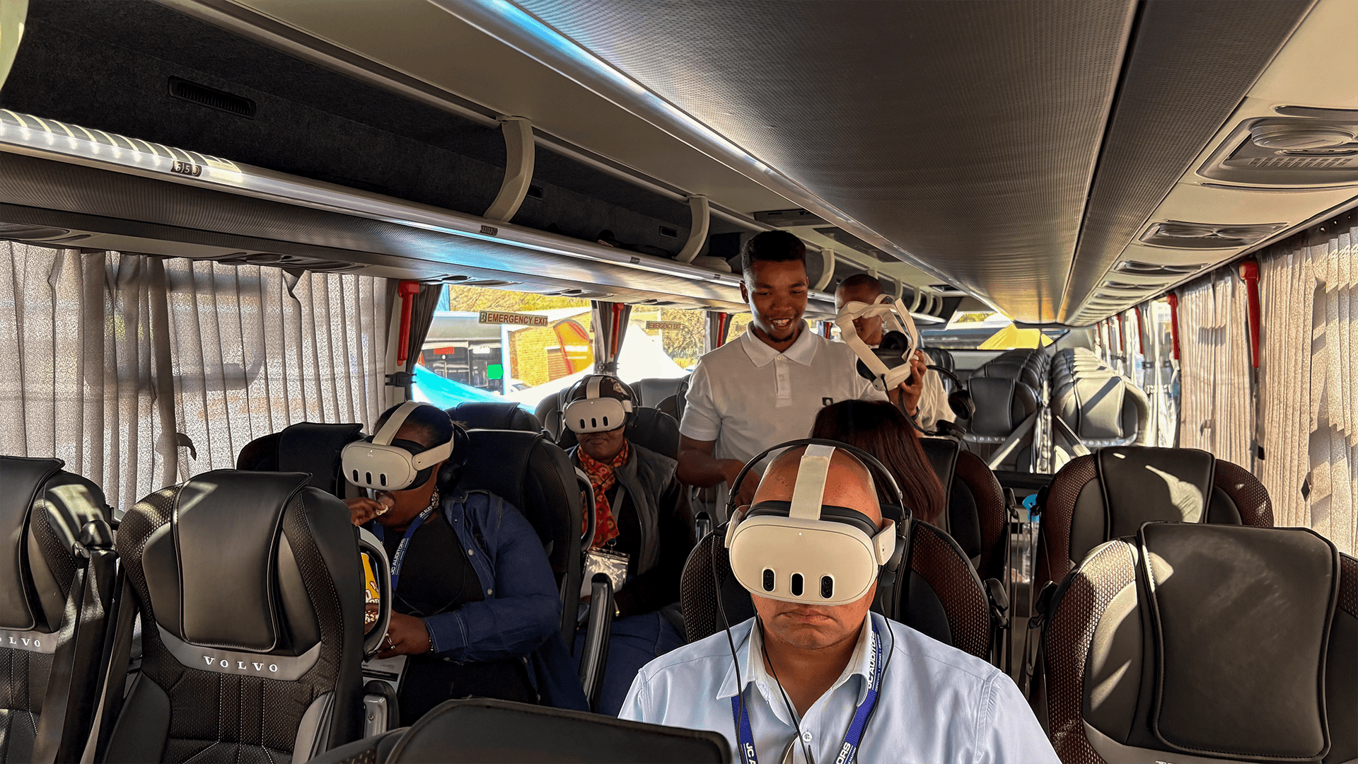 Passengers trying virtual reality experiences inside a coach