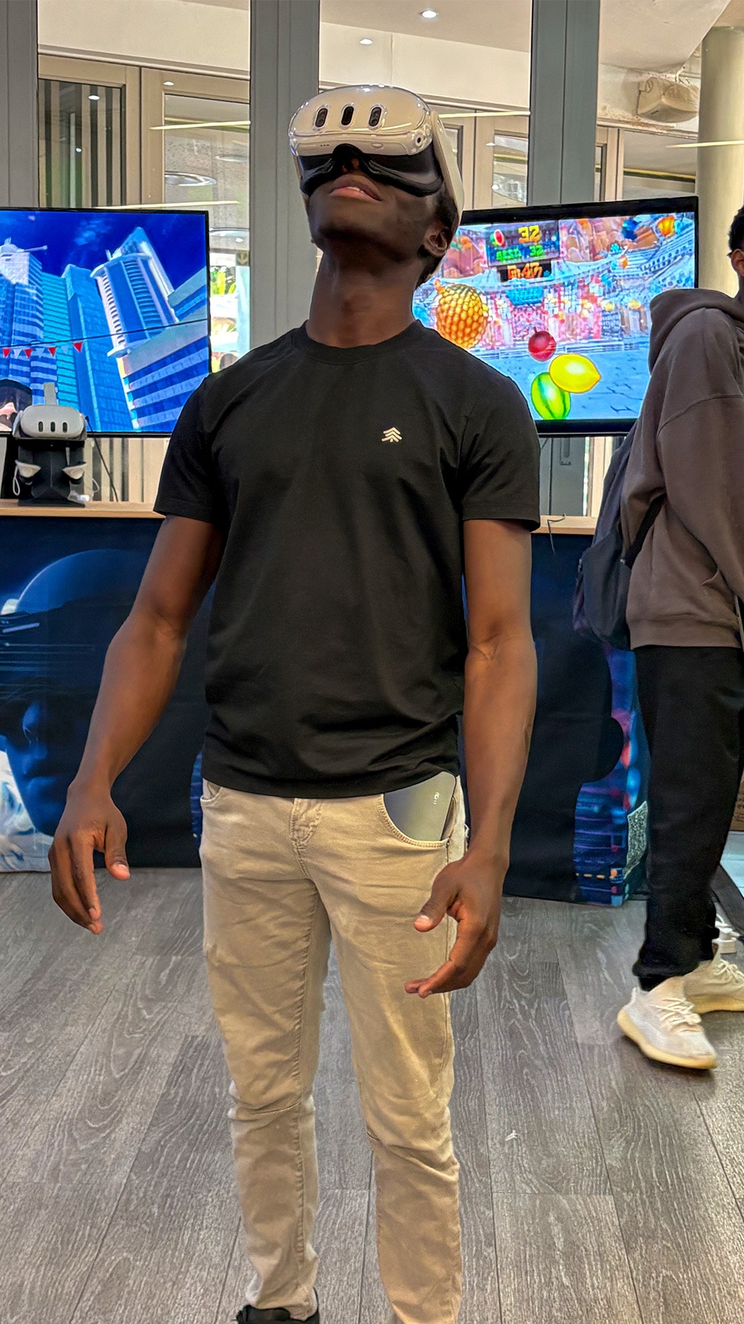 A guest wearing a VR headset beside event demonstration screens