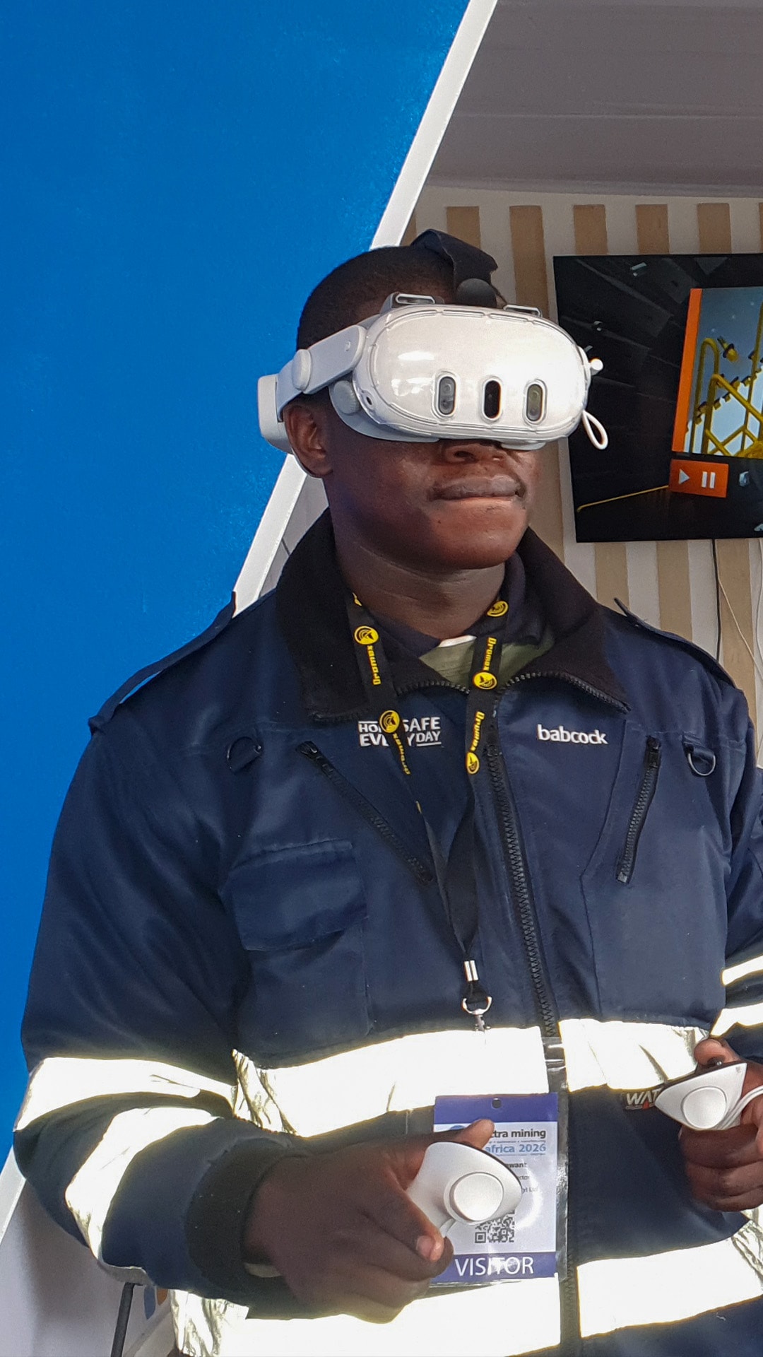 A participant holding VR controllers at an exhibition stand