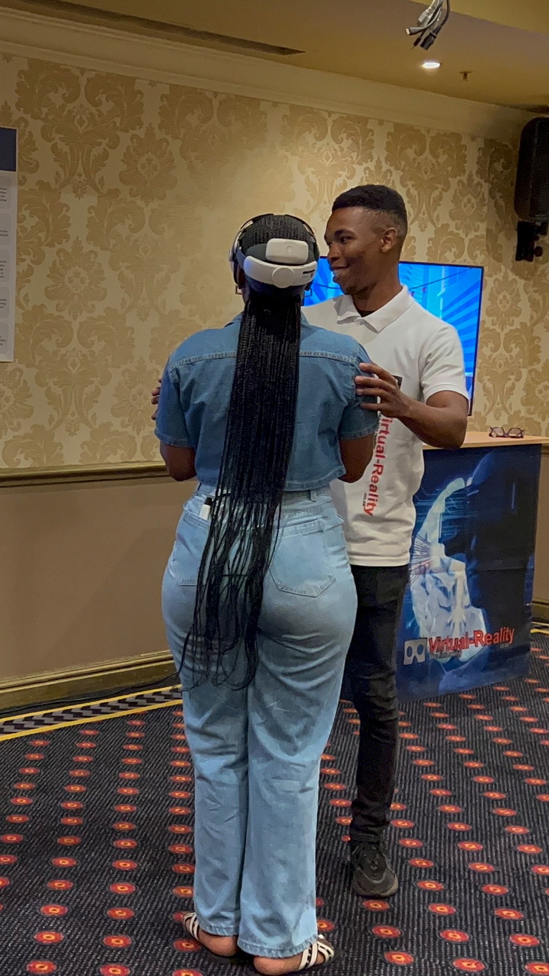 An event facilitator guiding a guest wearing a virtual reality headset
