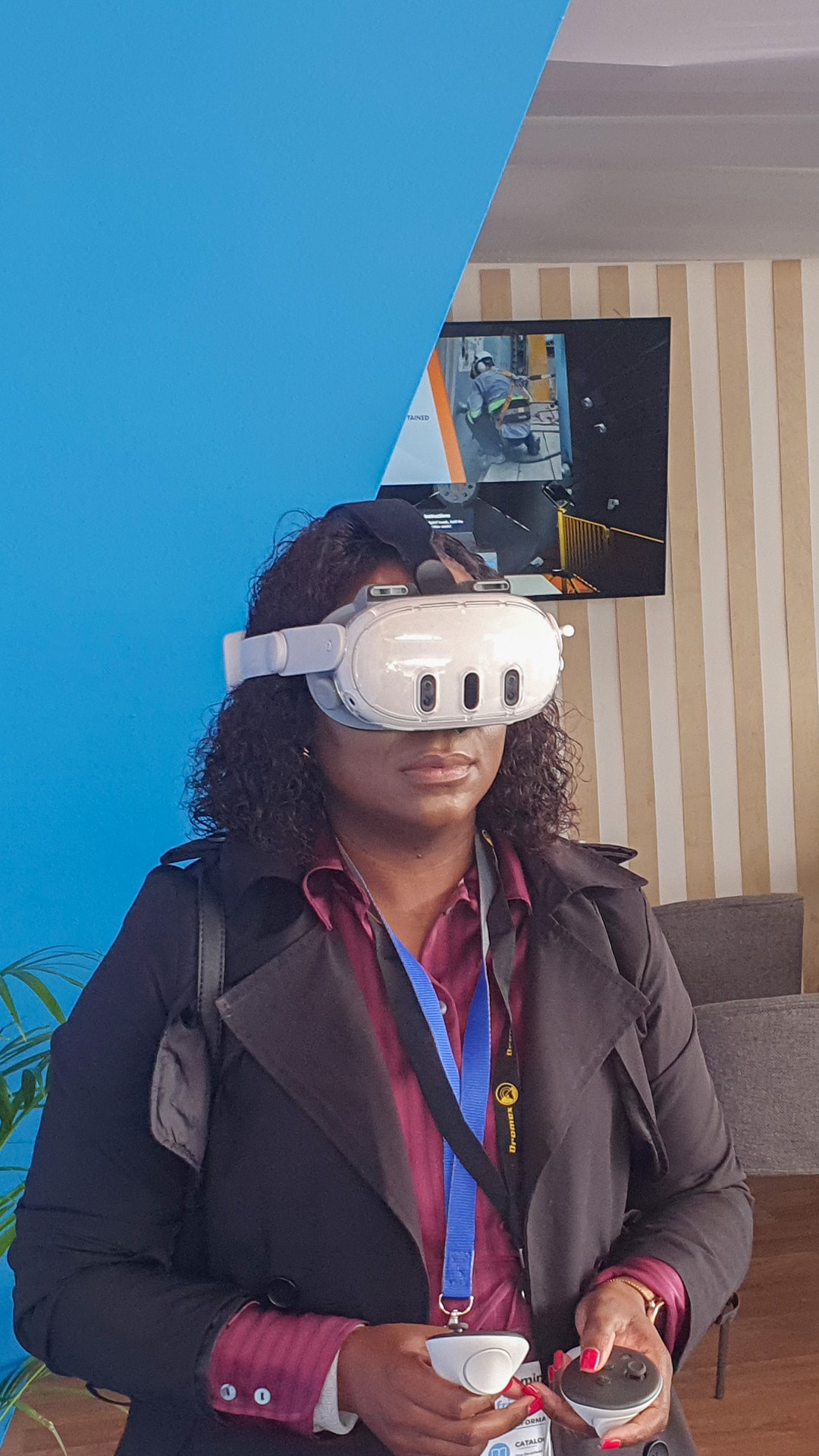 A participant holding controllers while wearing a VR headset at an exhibition