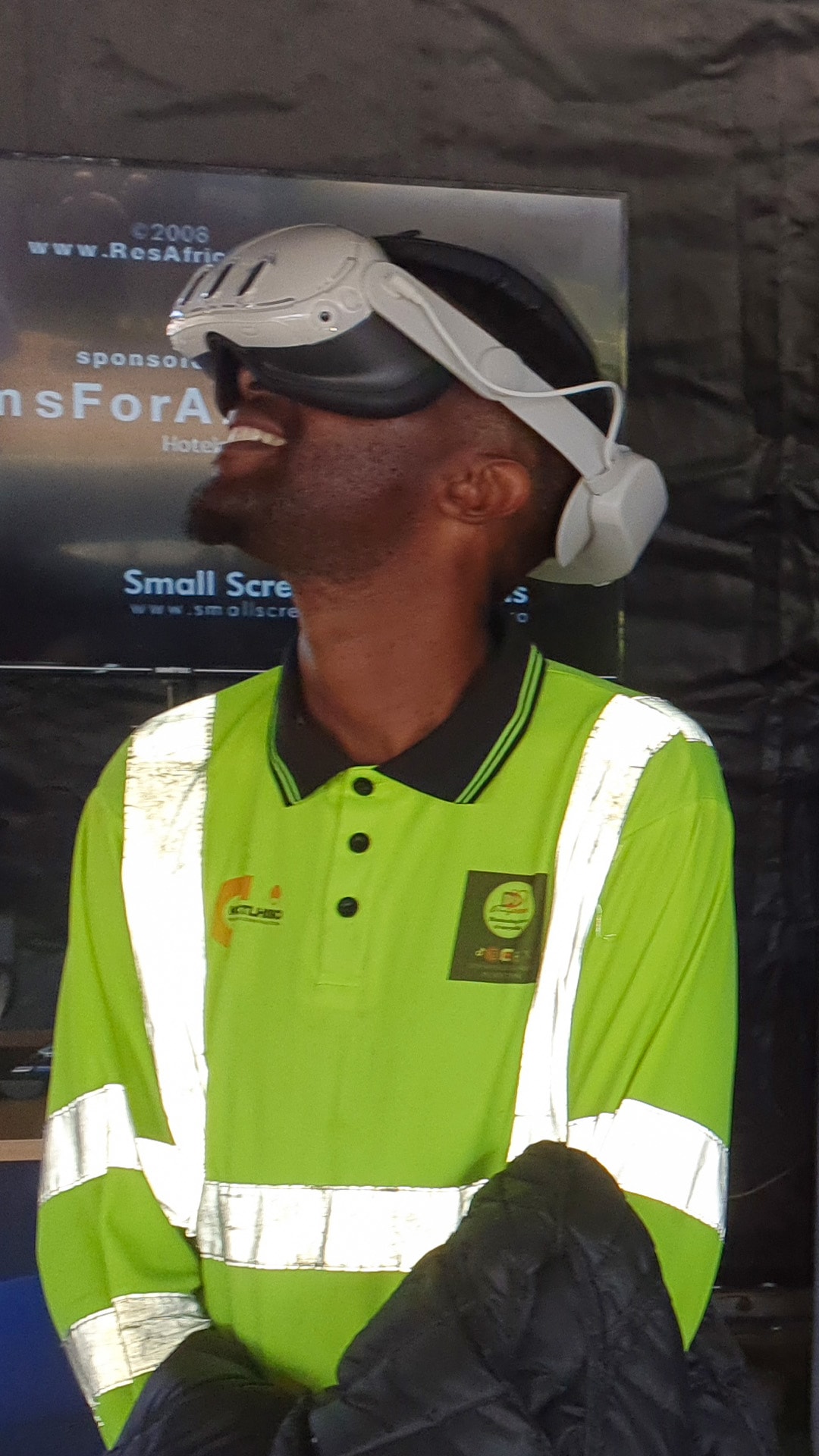 A participant in a reflective vest looking upward through a VR headset
