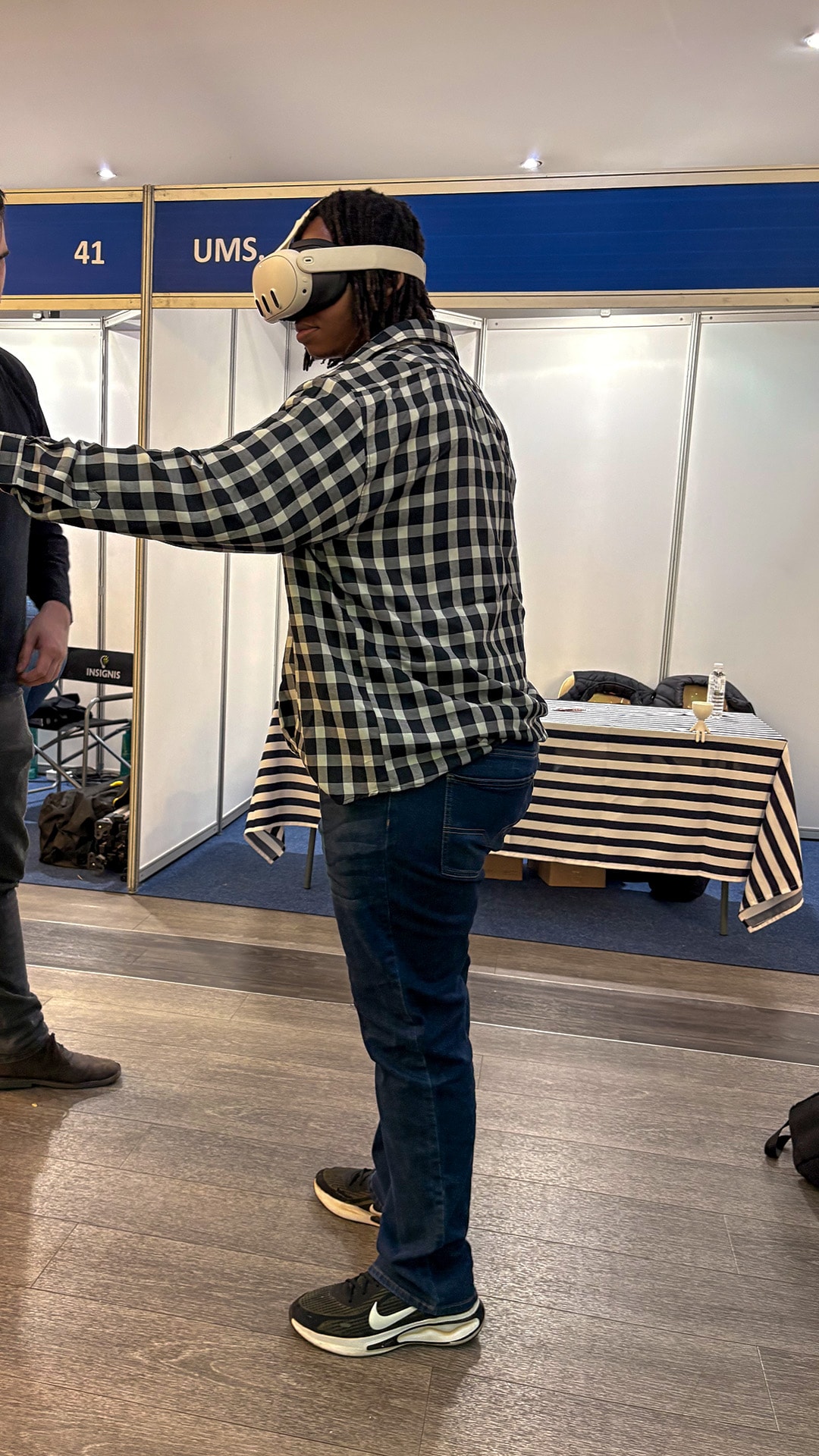 A participant in a checked shirt reaching out during a VR experience